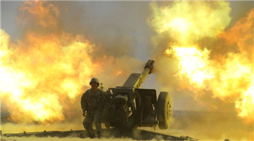Artilleryman fires towed howitzer