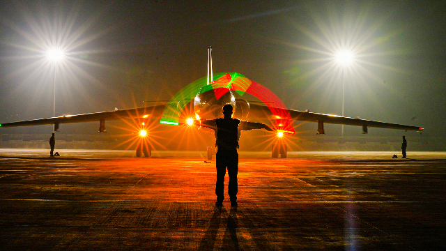 Airman guides aircraft at night