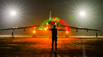 Airman guides aircraft at night