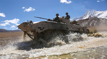 Armored vehicle wades through water obstacle